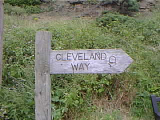 A sign marking the direction of the Cleveland Way National Trail at the top of Church Street, Staithes.